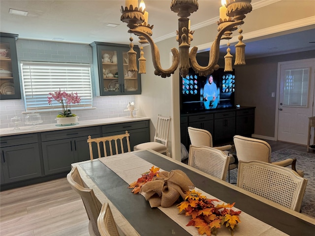 dining space with light hardwood / wood-style flooring and crown molding