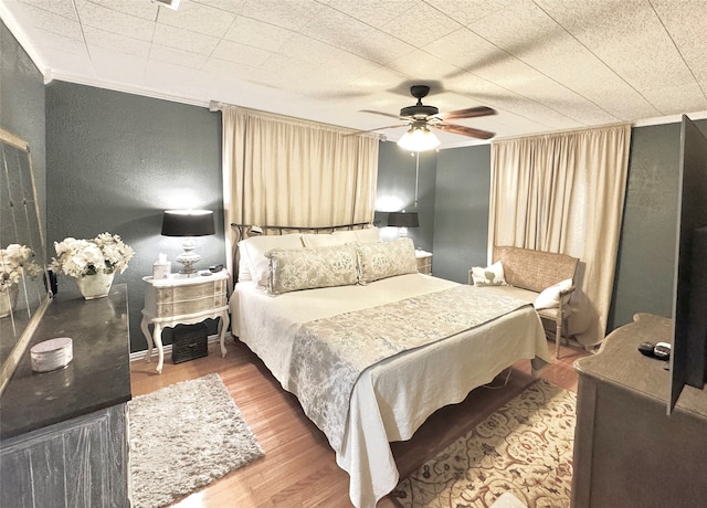 bedroom featuring ornamental molding, hardwood / wood-style floors, and ceiling fan