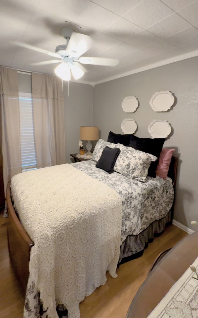 bedroom with ornamental molding, light hardwood / wood-style flooring, and ceiling fan