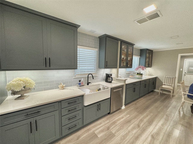 kitchen with stainless steel dishwasher, sink, light hardwood / wood-style floors, and a healthy amount of sunlight