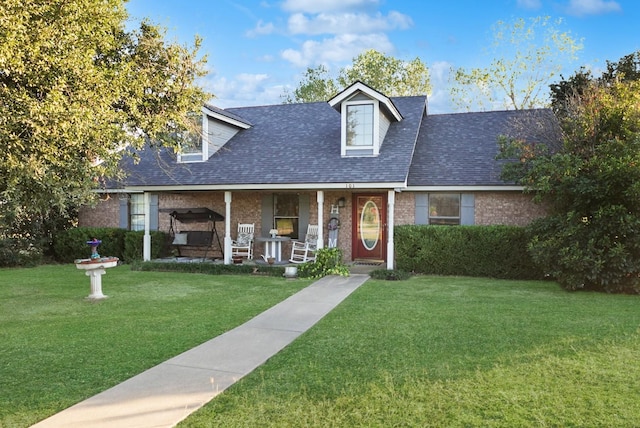 101 Scenic Dr, Dublin, TX 76446 - cape cod home with covered porch, a front lawn, a shingled roof, and brick siding