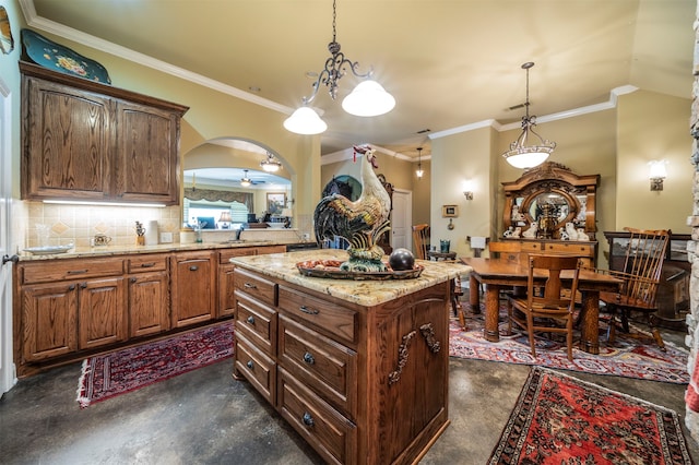 kitchen featuring ornamental molding, decorative backsplash, a center island, and hanging light fixtures