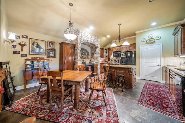 dining space featuring crown molding, sink, and vaulted ceiling