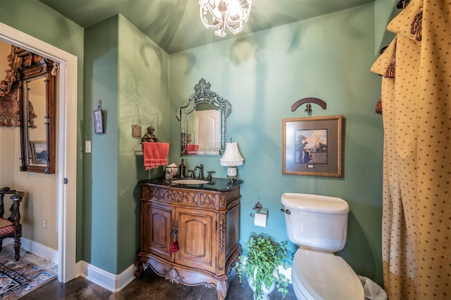 bathroom featuring vanity, toilet, and a notable chandelier