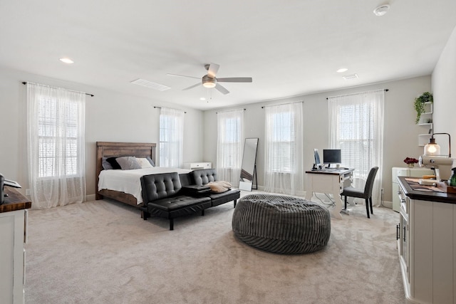 bedroom featuring multiple windows, light colored carpet, and ceiling fan