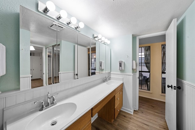 bathroom featuring a textured ceiling, wood-type flooring, and vanity