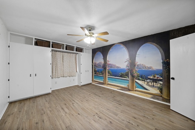 unfurnished bedroom featuring access to exterior, ceiling fan, and light wood-type flooring