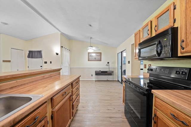 kitchen featuring black appliances, ceiling fan, sink, light hardwood / wood-style flooring, and lofted ceiling