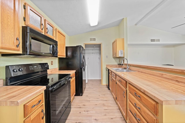 kitchen with black appliances, lofted ceiling, sink, and butcher block counters