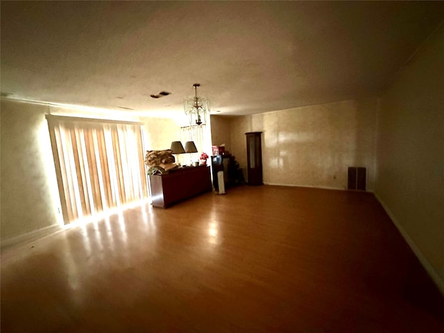 interior space with wood-type flooring and an inviting chandelier