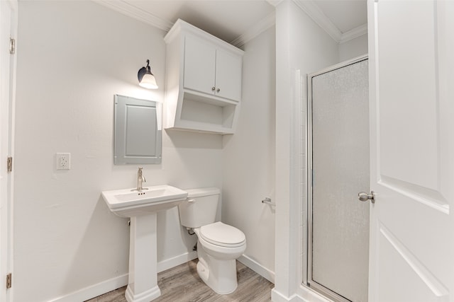 bathroom featuring toilet, crown molding, hardwood / wood-style floors, and a shower with shower door