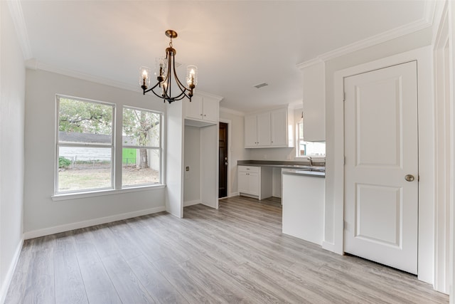 kitchen with light hardwood / wood-style floors, ornamental molding, hanging light fixtures, and white cabinets