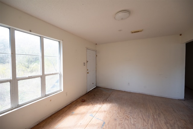 empty room featuring wood-type flooring and plenty of natural light