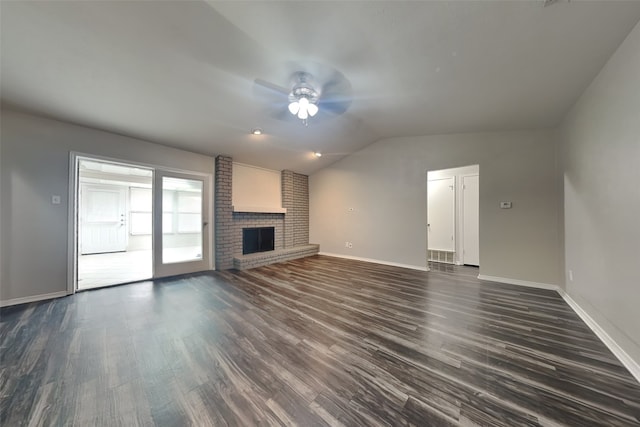 unfurnished living room with vaulted ceiling, a brick fireplace, dark hardwood / wood-style floors, and ceiling fan