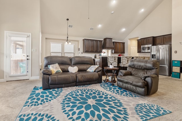 carpeted living room with high vaulted ceiling