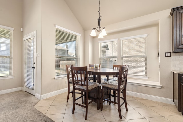 dining space featuring a wealth of natural light, lofted ceiling, an inviting chandelier, and light tile patterned floors