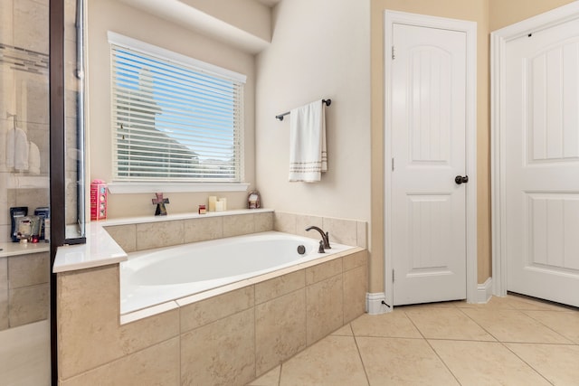 bathroom with tiled bath and tile patterned floors