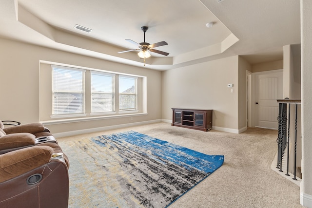 interior space with ceiling fan and a raised ceiling