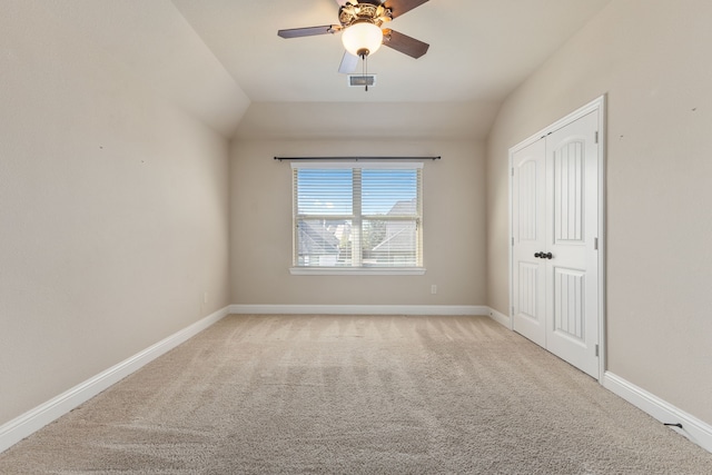 carpeted spare room with lofted ceiling and ceiling fan