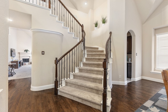 stairs featuring high vaulted ceiling and hardwood / wood-style floors