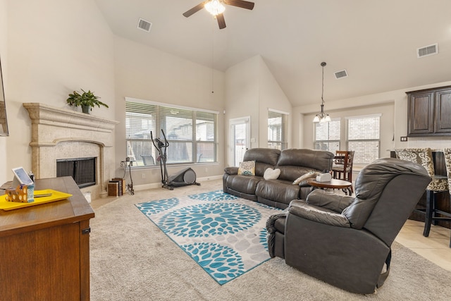 living room featuring light colored carpet, ceiling fan, high vaulted ceiling, and a fireplace