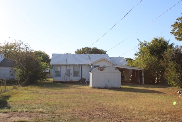 rear view of house with a shed and a lawn