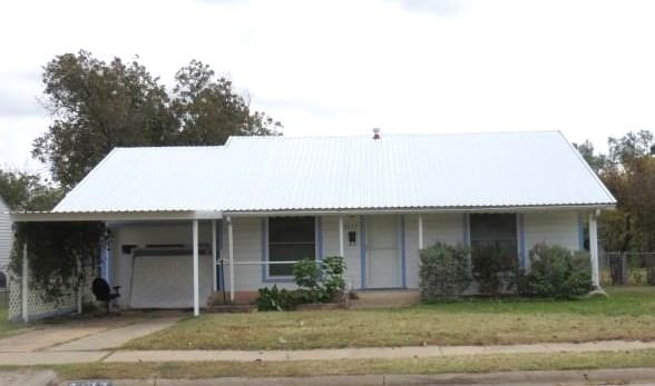 ranch-style home with a porch, a front lawn, and a garage