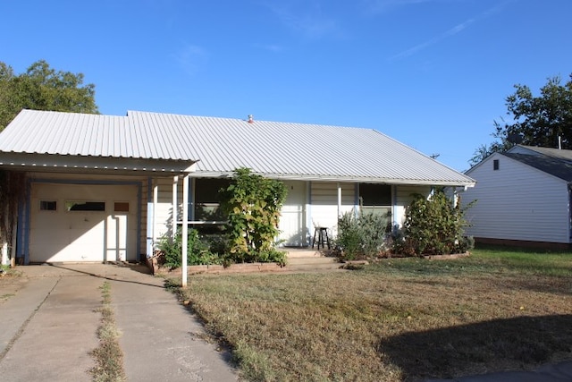 view of front of property with covered porch, a front lawn, and a garage