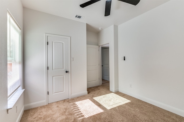 unfurnished bedroom featuring light colored carpet and ceiling fan