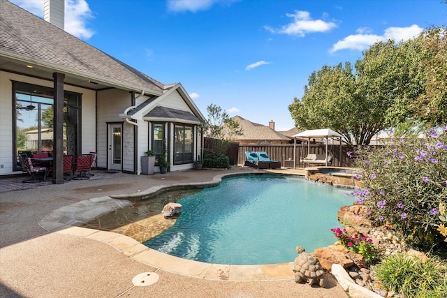 view of swimming pool featuring a patio area and an in ground hot tub