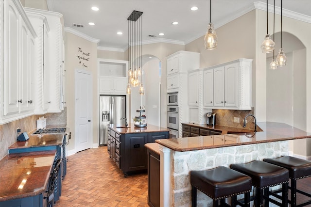 kitchen featuring kitchen peninsula, a center island, white cabinets, and stainless steel appliances