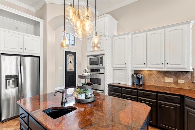 kitchen with decorative backsplash, appliances with stainless steel finishes, sink, dark stone countertops, and white cabinetry