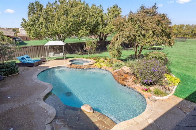 view of pool with a lawn, a patio area, and an in ground hot tub