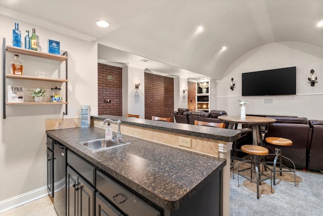 kitchen with ornamental molding, kitchen peninsula, sink, and vaulted ceiling