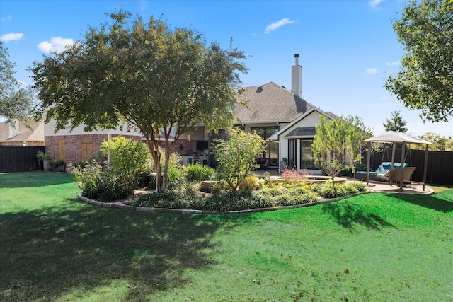 rear view of house featuring a lawn and a patio