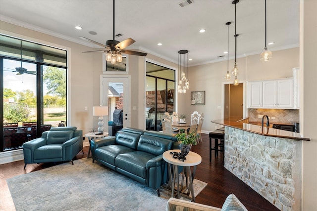 living room with ceiling fan, dark hardwood / wood-style flooring, and ornamental molding