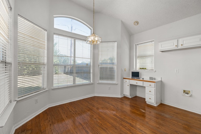 unfurnished office featuring built in desk, an inviting chandelier, a textured ceiling, vaulted ceiling, and dark wood-type flooring