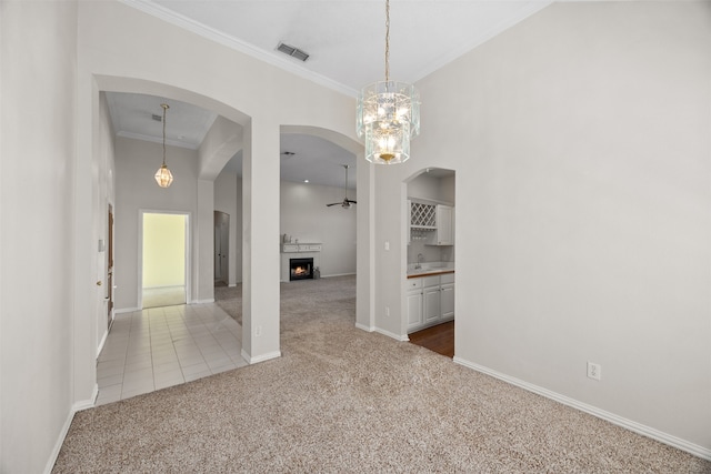 unfurnished dining area featuring ornamental molding, carpet, and ceiling fan