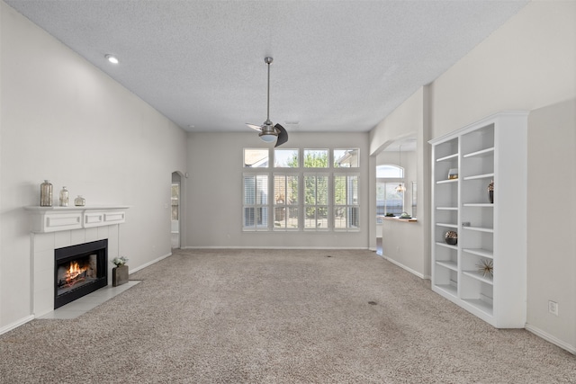 unfurnished living room featuring a textured ceiling, light carpet, and a fireplace