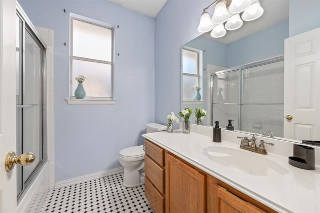 full bathroom featuring vanity, toilet, and bath / shower combo with glass door