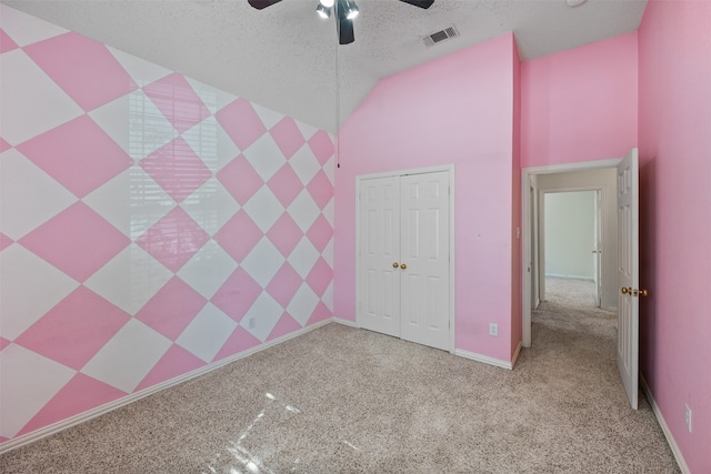 unfurnished bedroom with light carpet, a textured ceiling, a closet, and ceiling fan