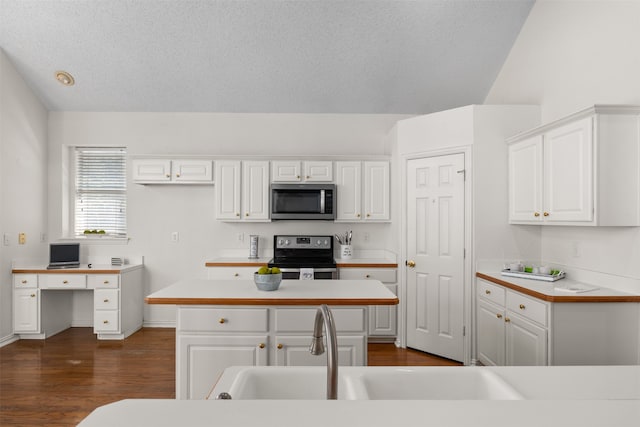 kitchen featuring a center island, white cabinets, stainless steel appliances, and dark wood-type flooring