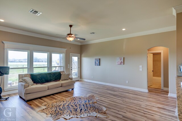 living room with built in shelves, ornamental molding, dark hardwood / wood-style floors, and a healthy amount of sunlight