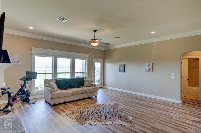 carpeted bedroom with crown molding, a tray ceiling, and ceiling fan