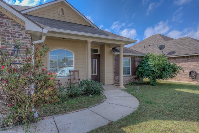 view of exterior entry with a lawn