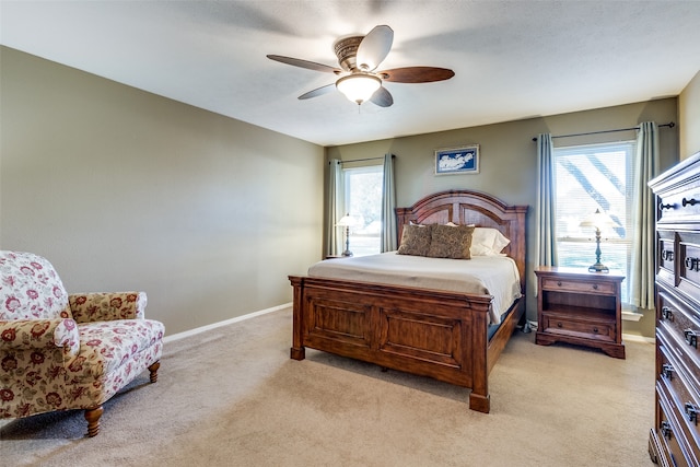 carpeted bedroom with ceiling fan and multiple windows