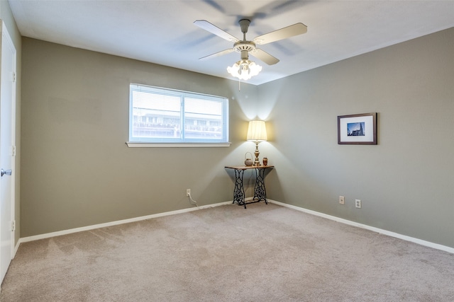 carpeted spare room with ceiling fan