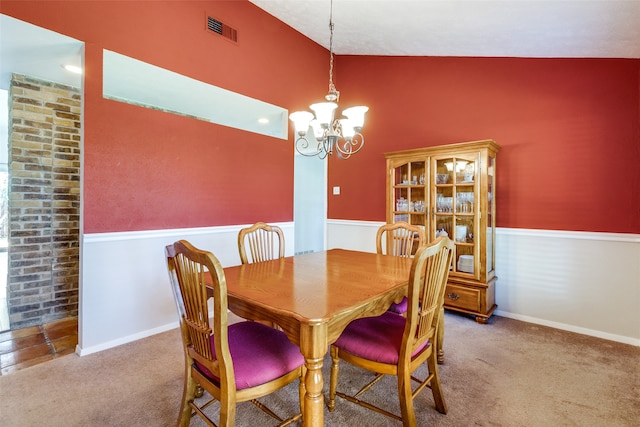 dining space featuring a notable chandelier, carpet flooring, and vaulted ceiling