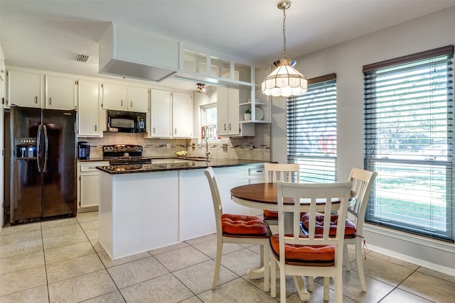 kitchen featuring white cabinetry, black appliances, plenty of natural light, and hanging light fixtures