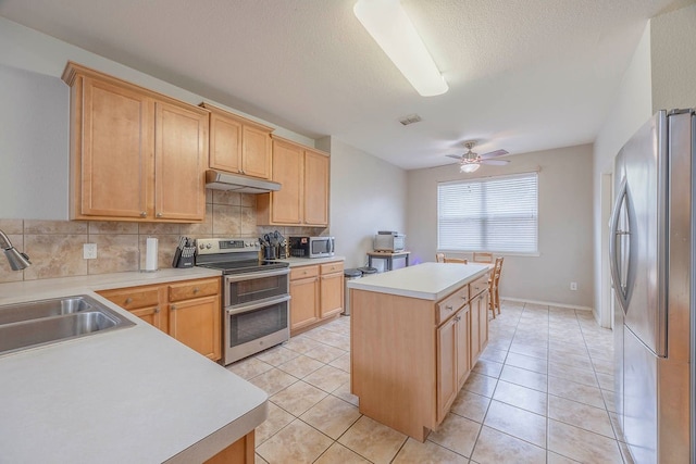 kitchen with a kitchen island, decorative backsplash, ceiling fan, and stainless steel appliances